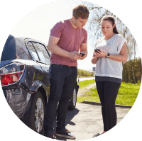 a man and a women exchanging insurance information after their car accident
