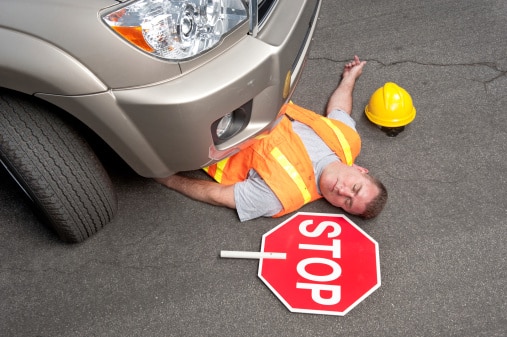 construction worker unconscious laying under a vehicle