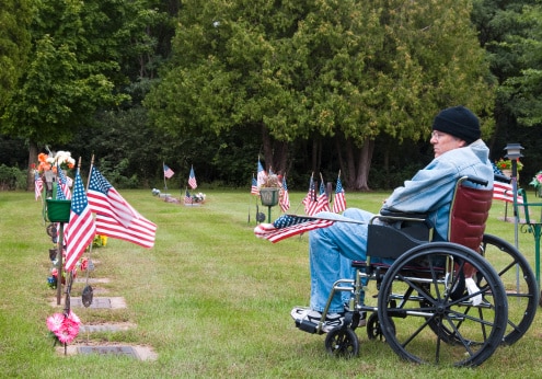 a handicapped veteran in a graveyard admiring fallin troops