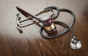 Medical Malpractice Attorney Baltimore MD - Gavel and Stethoscope on Reflective Wooden Table.