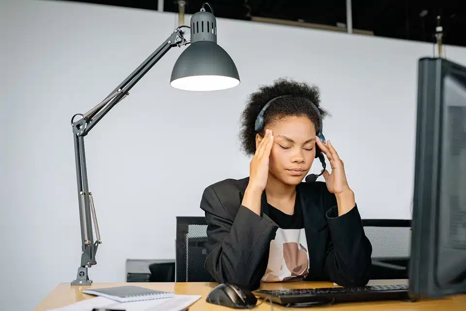 ODRISA, image of employee with headset sitting at desk rubbing temples, Disparti Law Group Accident & Injury Lawyers