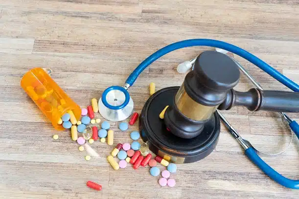 Prescribed the wrong medication, image of gavel next to spilled pills on table