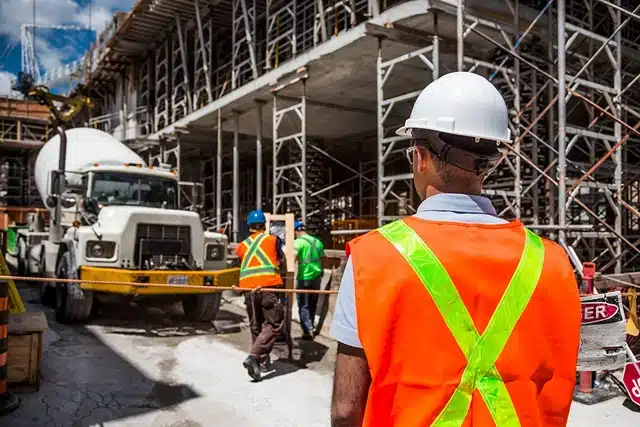 Common Causes of Scaffolding Accidents, image of construction workers standing on construction site with scaffolding