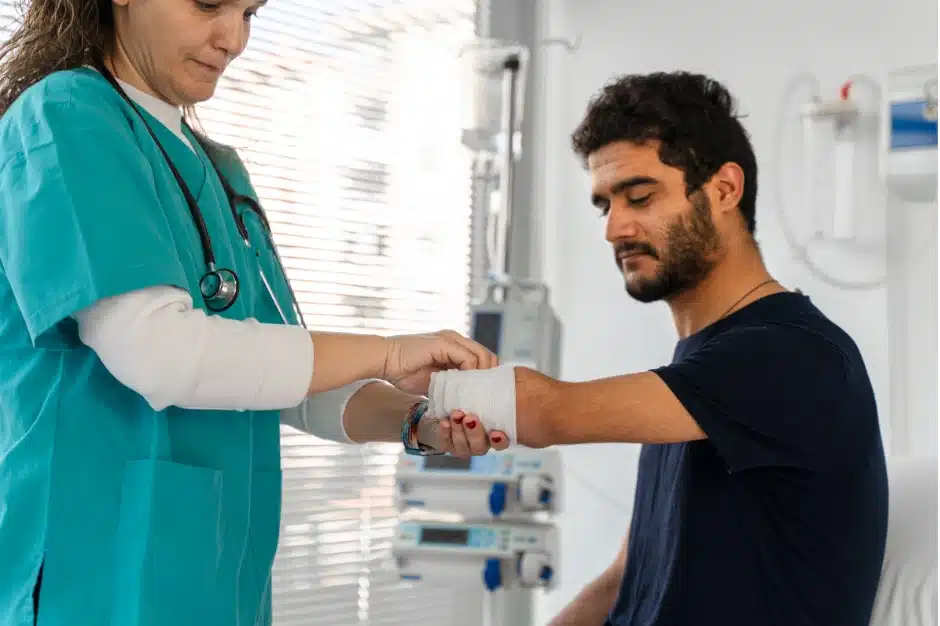 Causes of workplace amputation injuries, image of doctor wrapping amputation site on man's arm