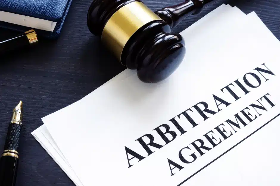 Labor arbitration, image of papers reading arbitration agreement on table near gavel and pen, Disparti Law Group