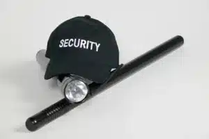 Unsafe work conditions, image of securty guard hat, flash light, and baton