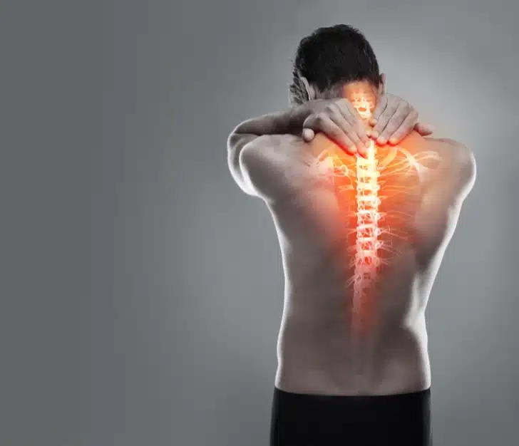 Degenerative disc disease, image of man's back no shirt highlighted spine, Disparti Law Group