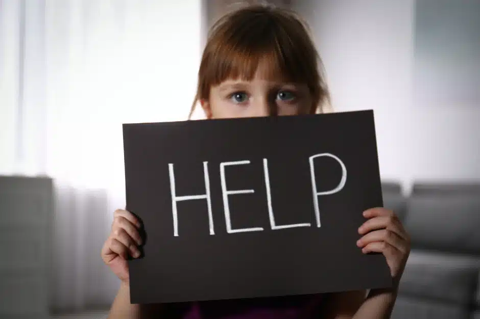 warning signs of sexual grooming, image of young girl holding help sign, Disparti Law Group