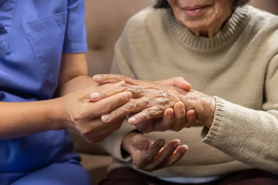 is rheumatoid arthritis a disability, image of doctor holding elderly woman's hand, Disparti Law Group
